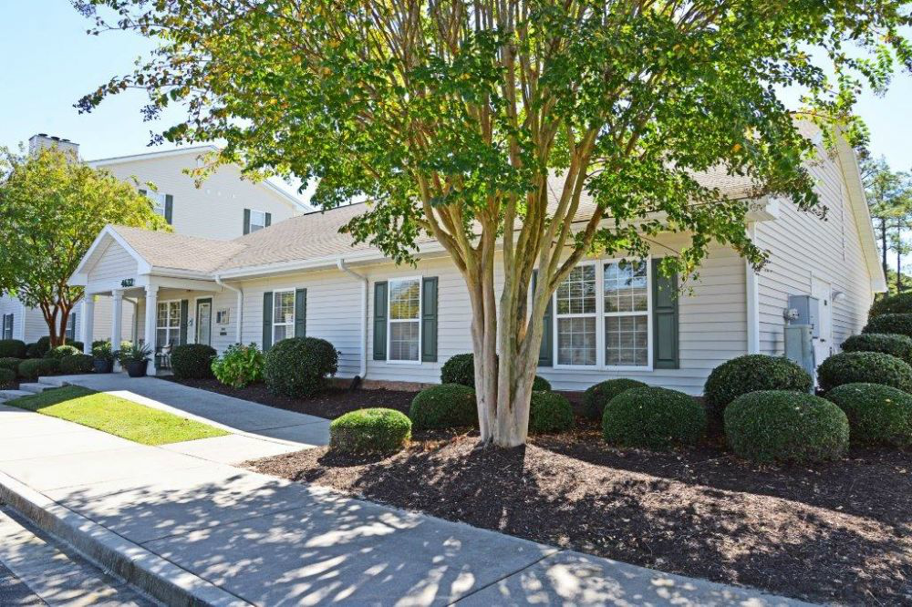 a white house with a tree in front of it