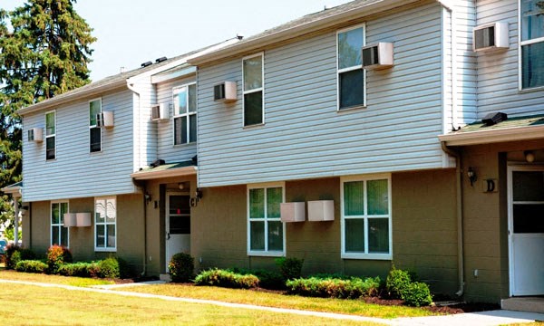 a white and gray house with a yard in front of it