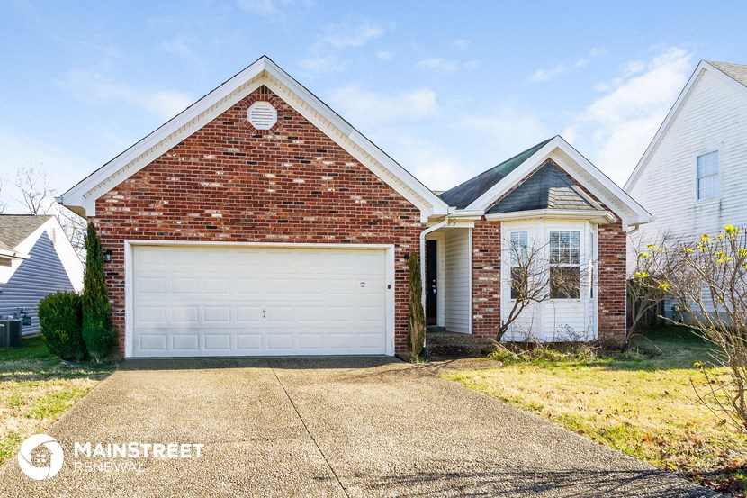a white garage door in front of a brick house