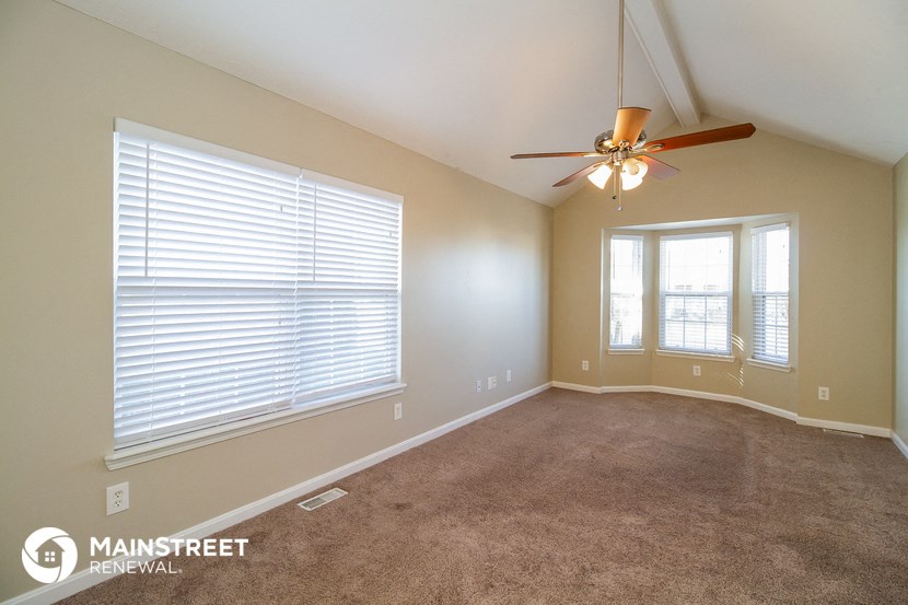 a living room with a ceiling fan and a large window