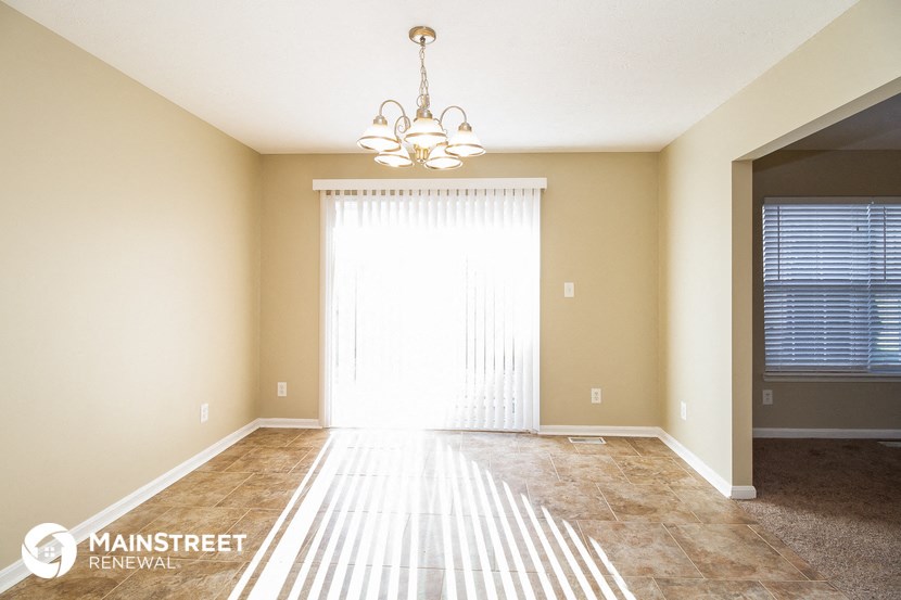 a dining room with a chandelier and a large window