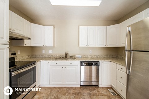 a kitchen with white cabinets and stainless steel appliances