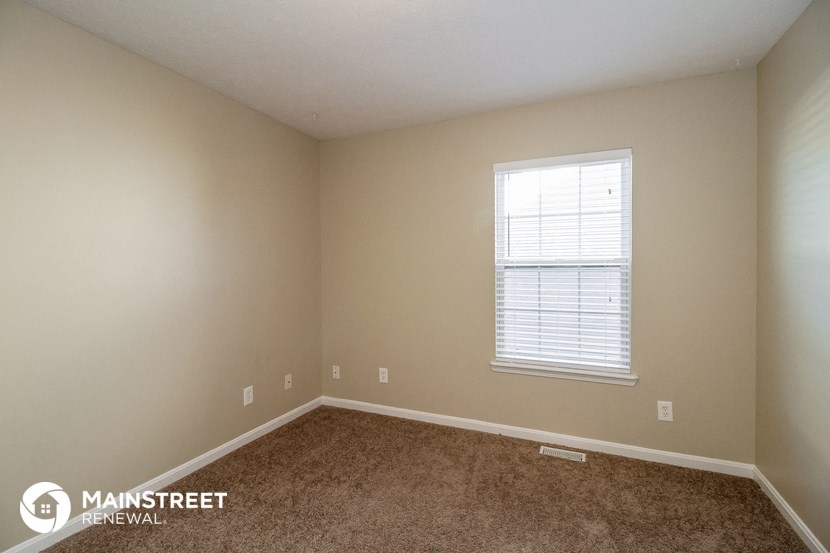 a bedroom with a carpeted floor and a window
