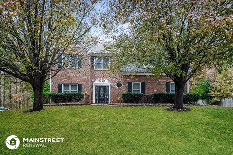 a brick house with two trees in front of it