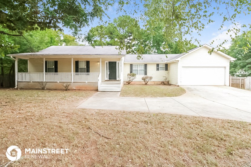 a small white house with a driveway and a porch