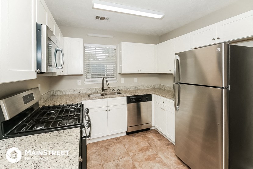 a kitchen with stainless steel appliances and white cabinets
