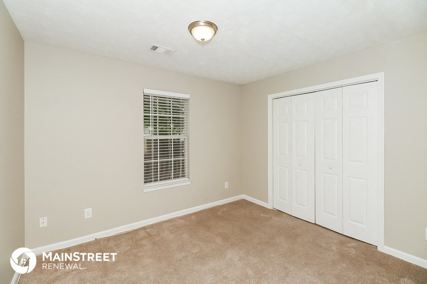 the master bedroom has a carpeted floor and two closets