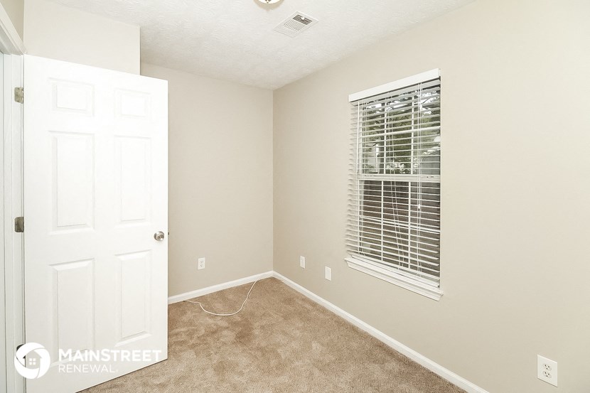 a bedroom with a white door and a window