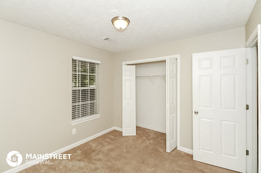 a bedroom with two closets and a door to a closet