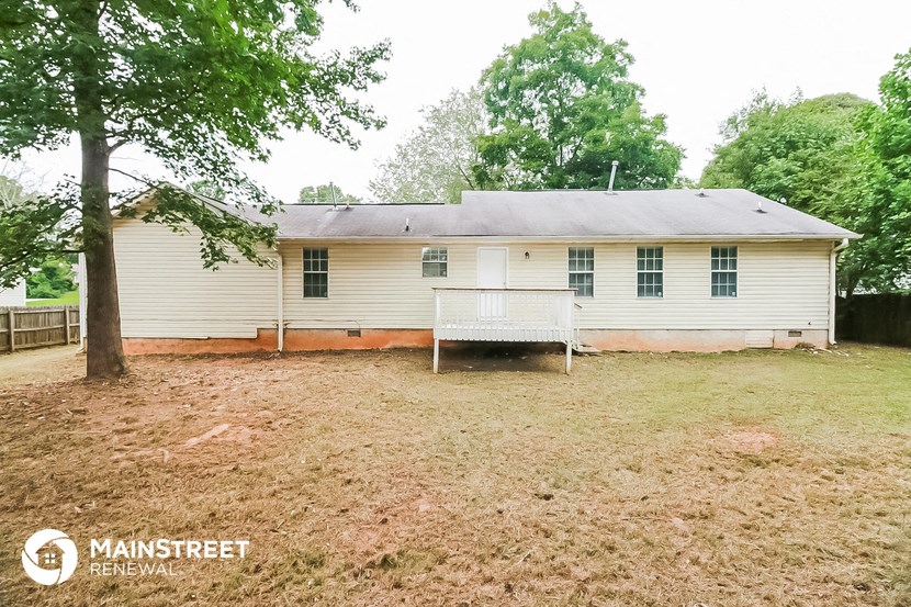 a small white house with a yard and a bench