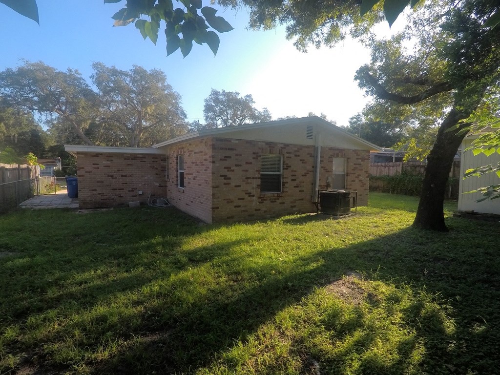 a small brick house with a yard and a tree