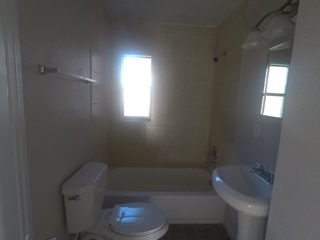 a bathroom with a sink toilet and a bath tub