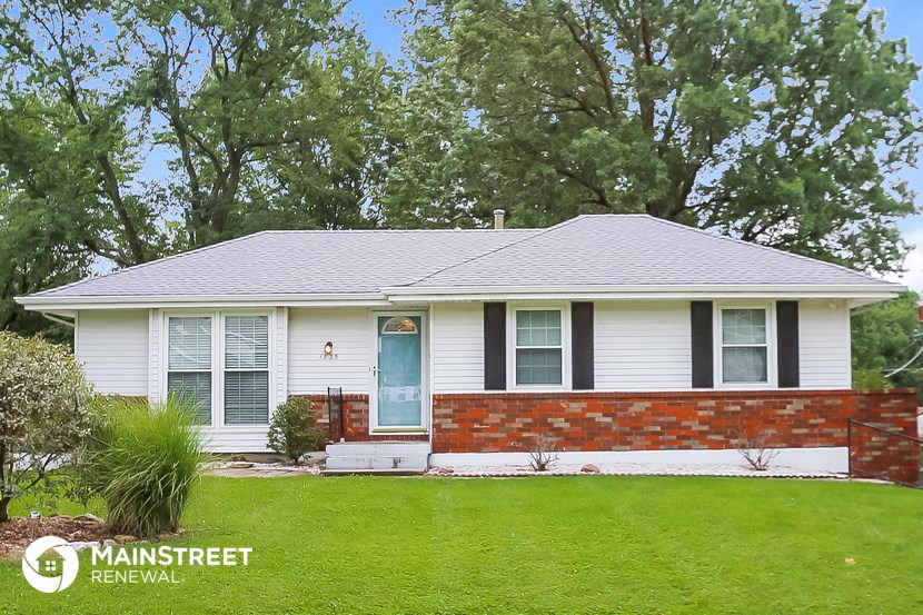a white house with black shutters and a green lawn