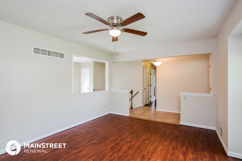 the living room and dining room with hardwood flooring and ceiling fan