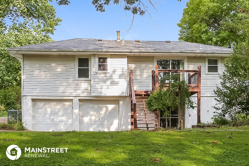 a white house with two garage doors and a porch