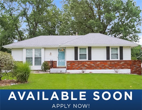 a white house with a green lawn and a blue door