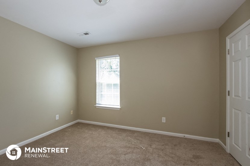 a bedroom with a carpeted floor and a window