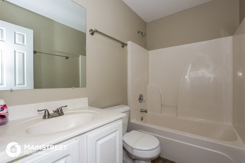 a bathroom with a sink toilet and a tub and a mirror