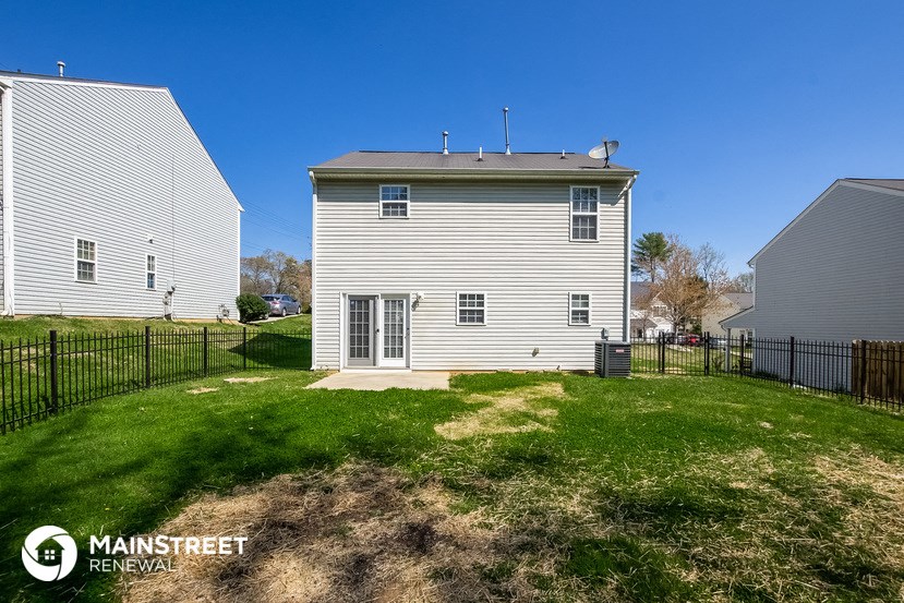 a white house with a yard and a black fence