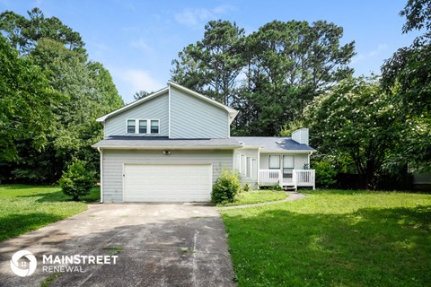 a white house with a driveway and a white garage door