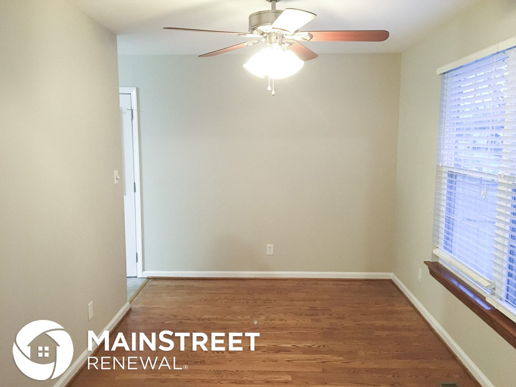 an empty room with a ceiling fan and a window