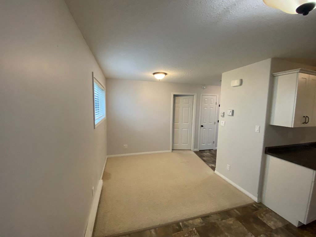 the living room and kitchen of an empty house