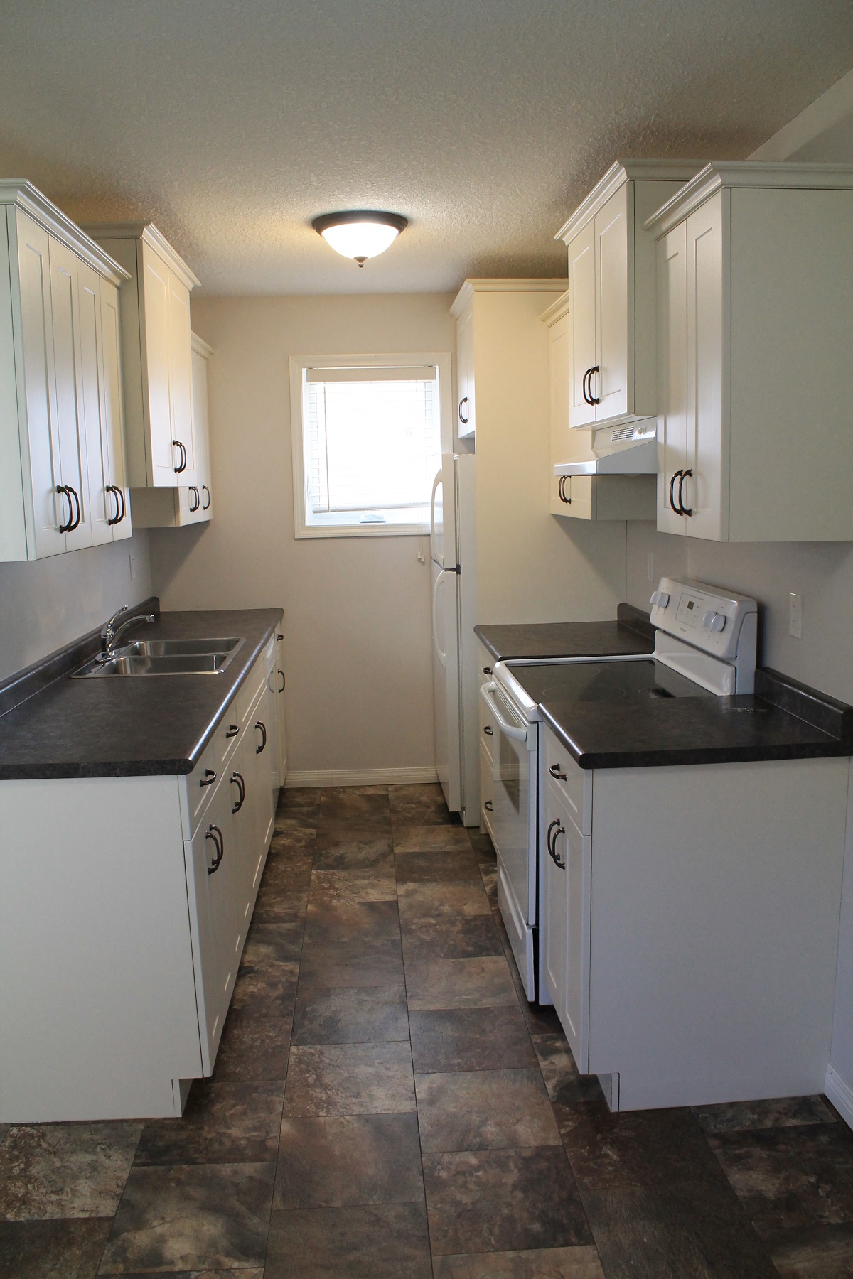 a kitchen with white cabinets and a sink and a window