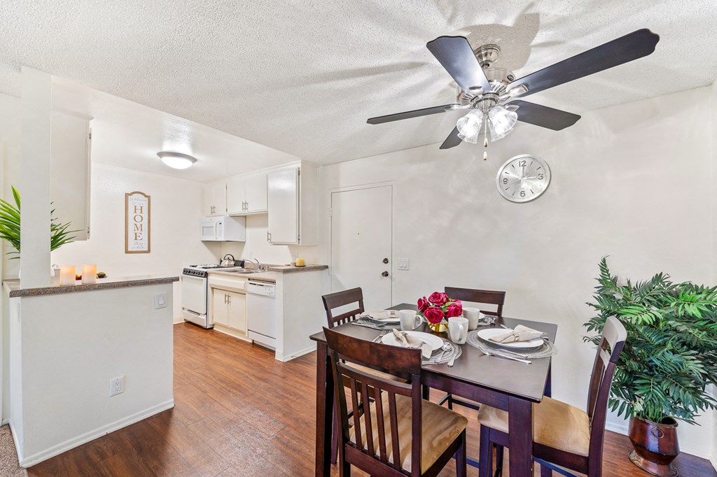a dining room with a table and chairs and a ceiling fan