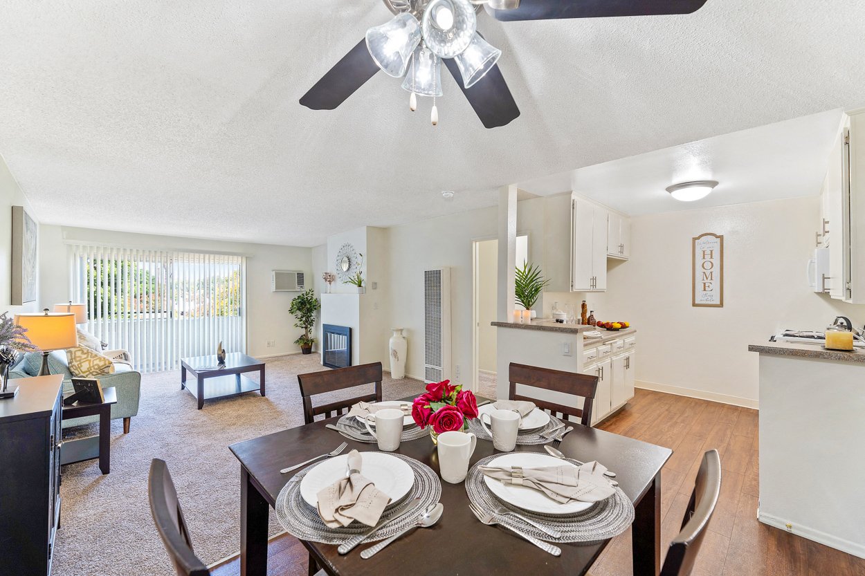 a living room with a dining room table and a ceiling fan
