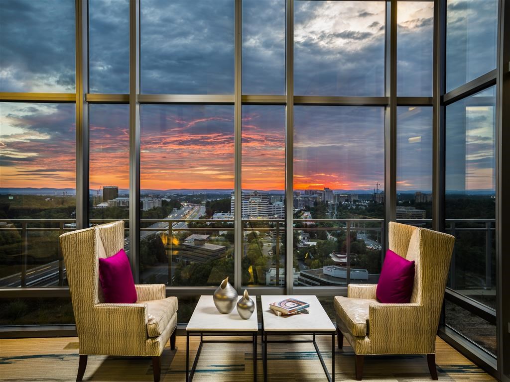 a view of a sunset from a hotel room with a table and chairs
