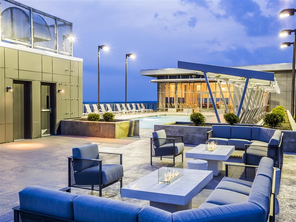 a lounge area with couches and tables in front of a pool