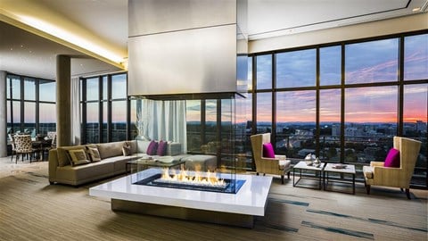 a living room with a fireplace and a view of the city