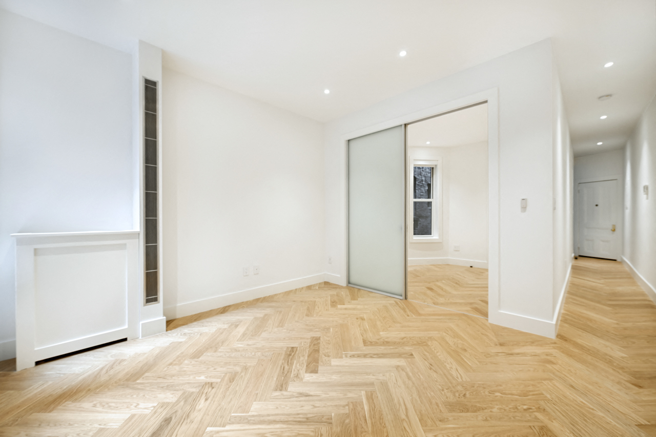 a living room with a hardwood floor and a sliding glass door