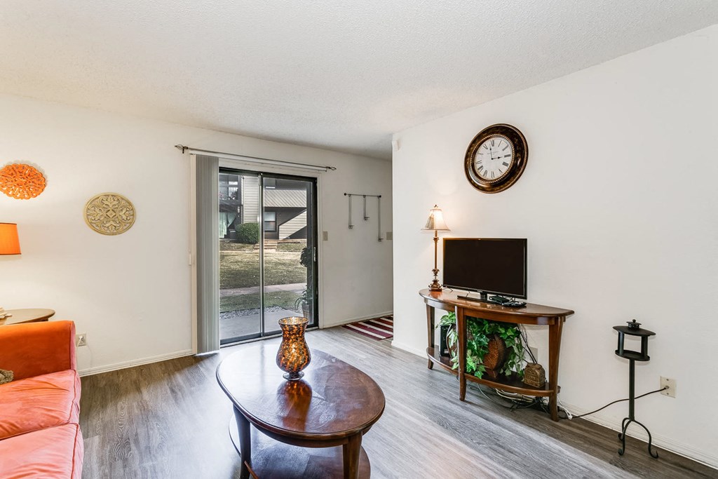 a living room with a tv and a sliding glass door