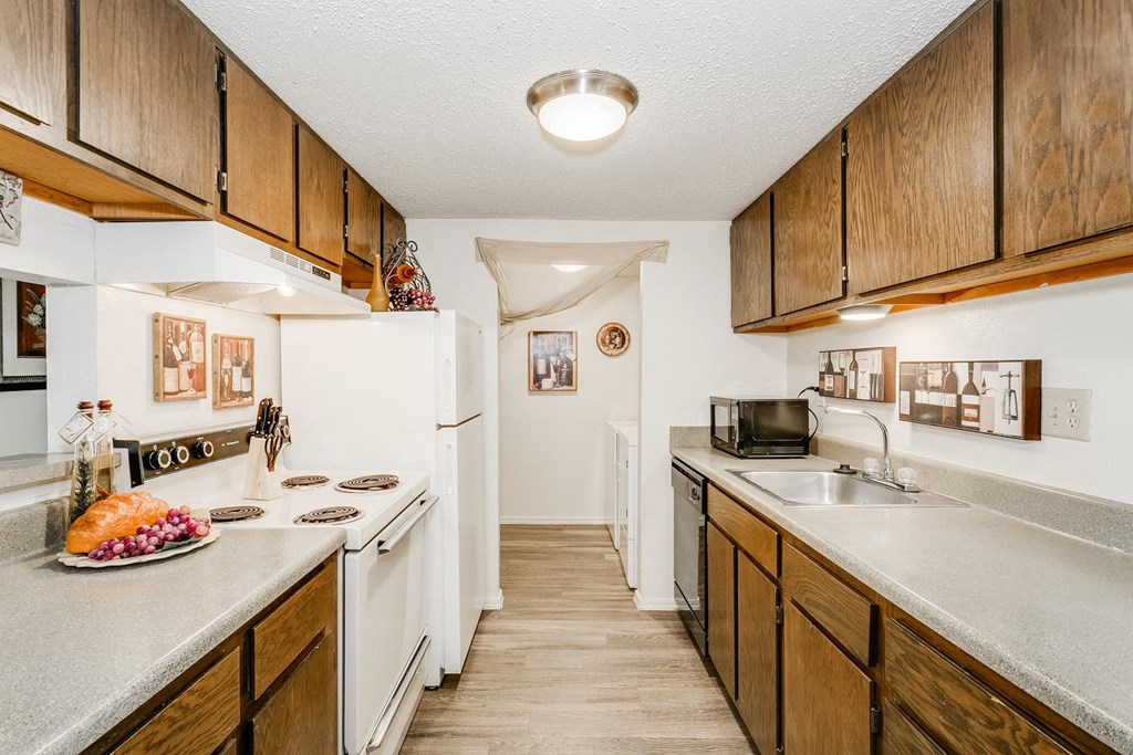a kitchen with white appliances and wooden cabinets