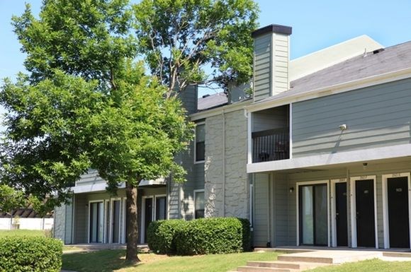 a gray house with a tree in front of it