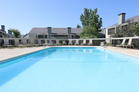 a large swimming pool with chairs around it