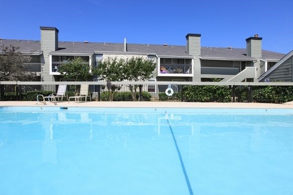 a large swimming pool with a building in the background