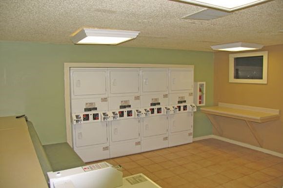 a kitchen with white cabinets and a green wall
