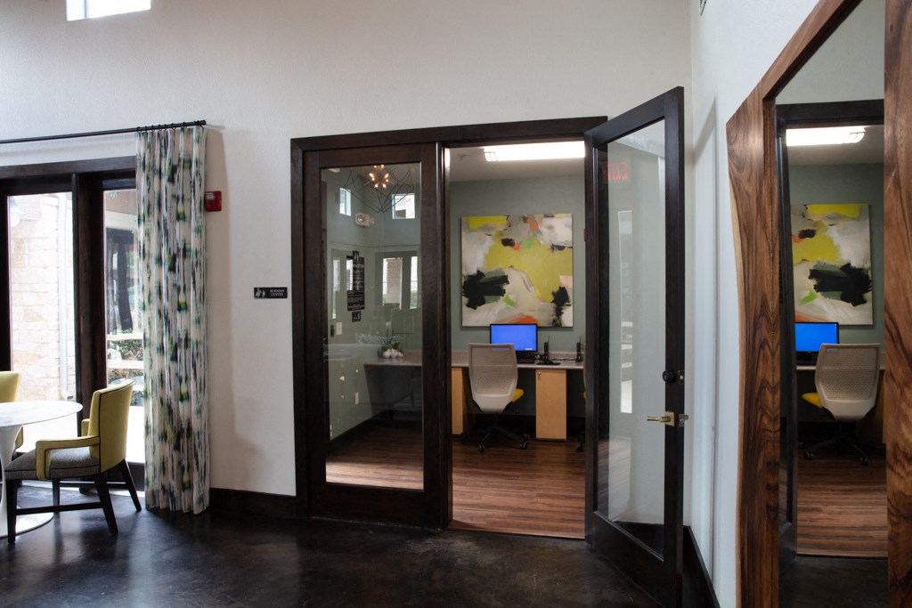 a view of a conference room with open doors and a desk with a computer
