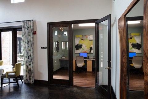 a view of a conference room with open doors and a desk with a computer
