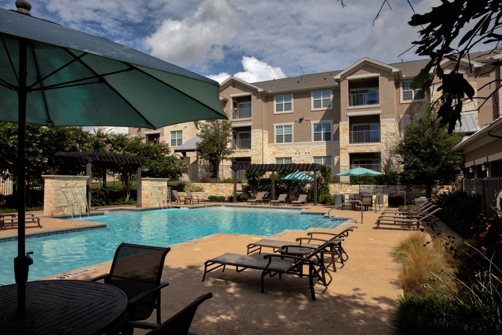 our apartments have a large swimming pool with chairs and umbrellas