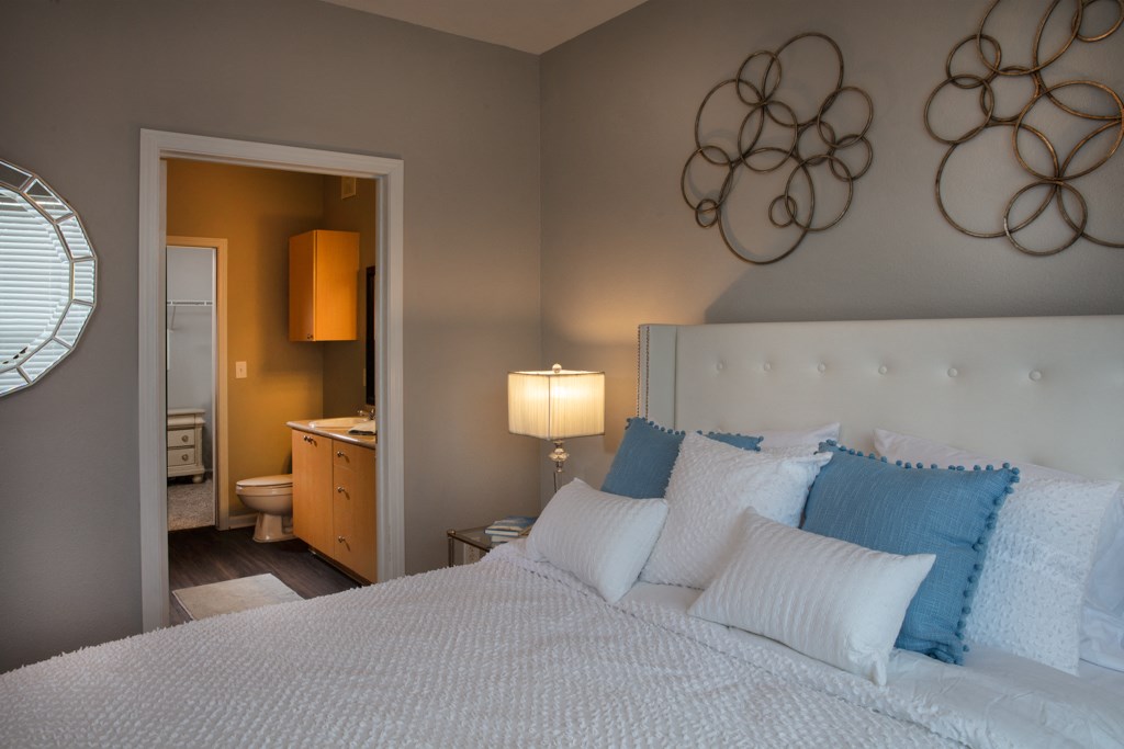 a bedroom with a bed and a bathroom with a toilet