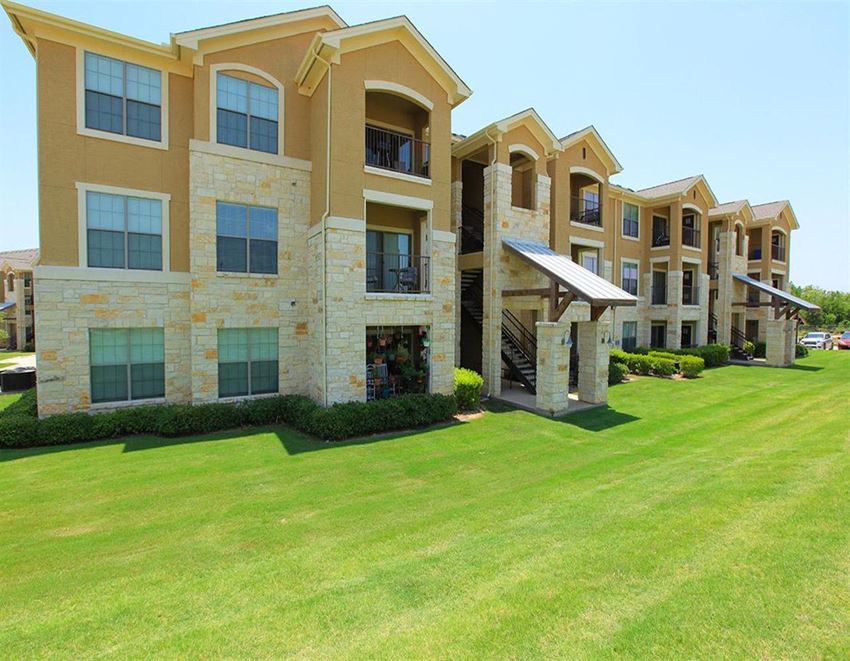a large building with a green lawn in front of it