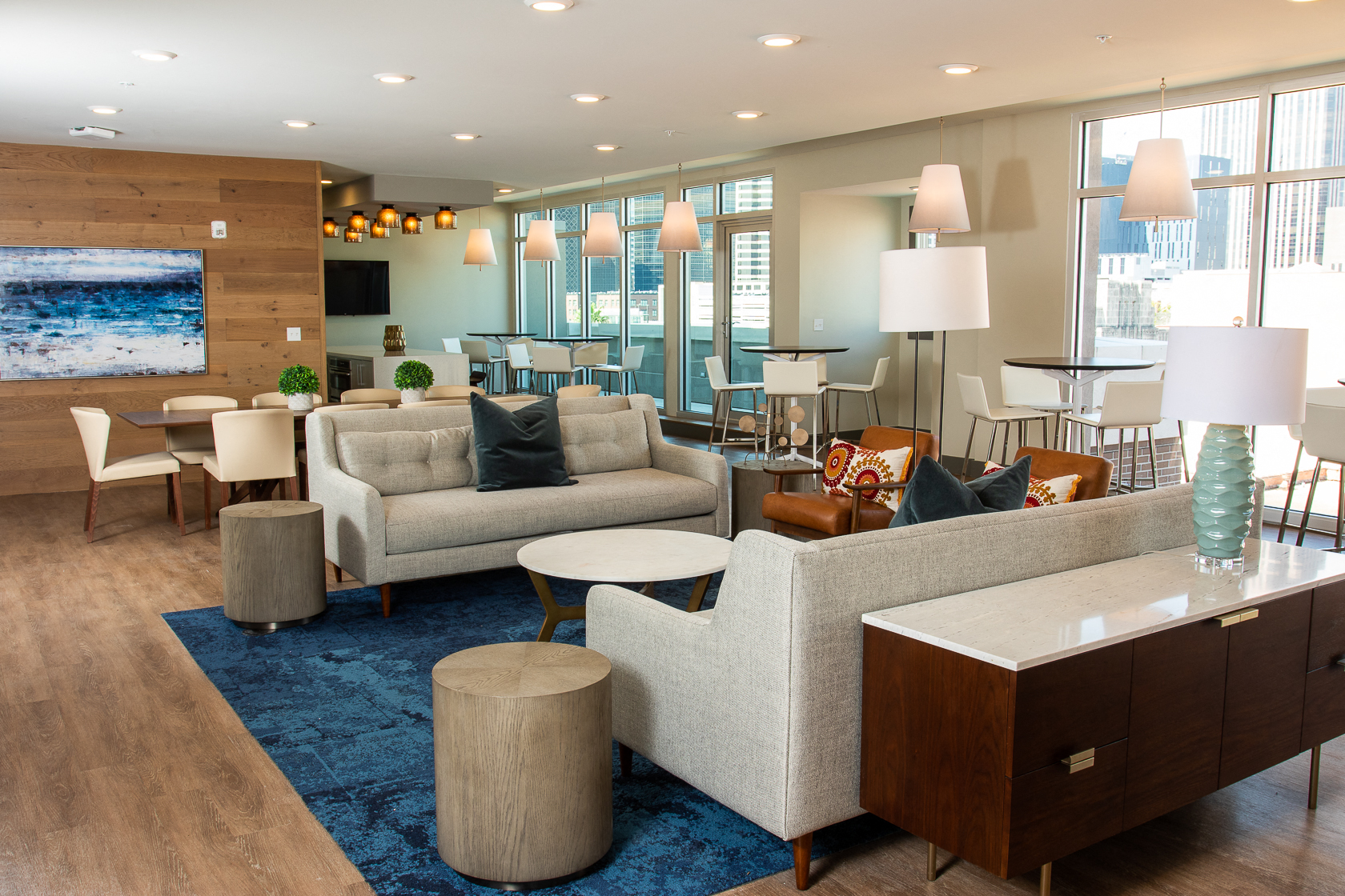 a living room with couches tables and chairs and a tv in a hotel lobby