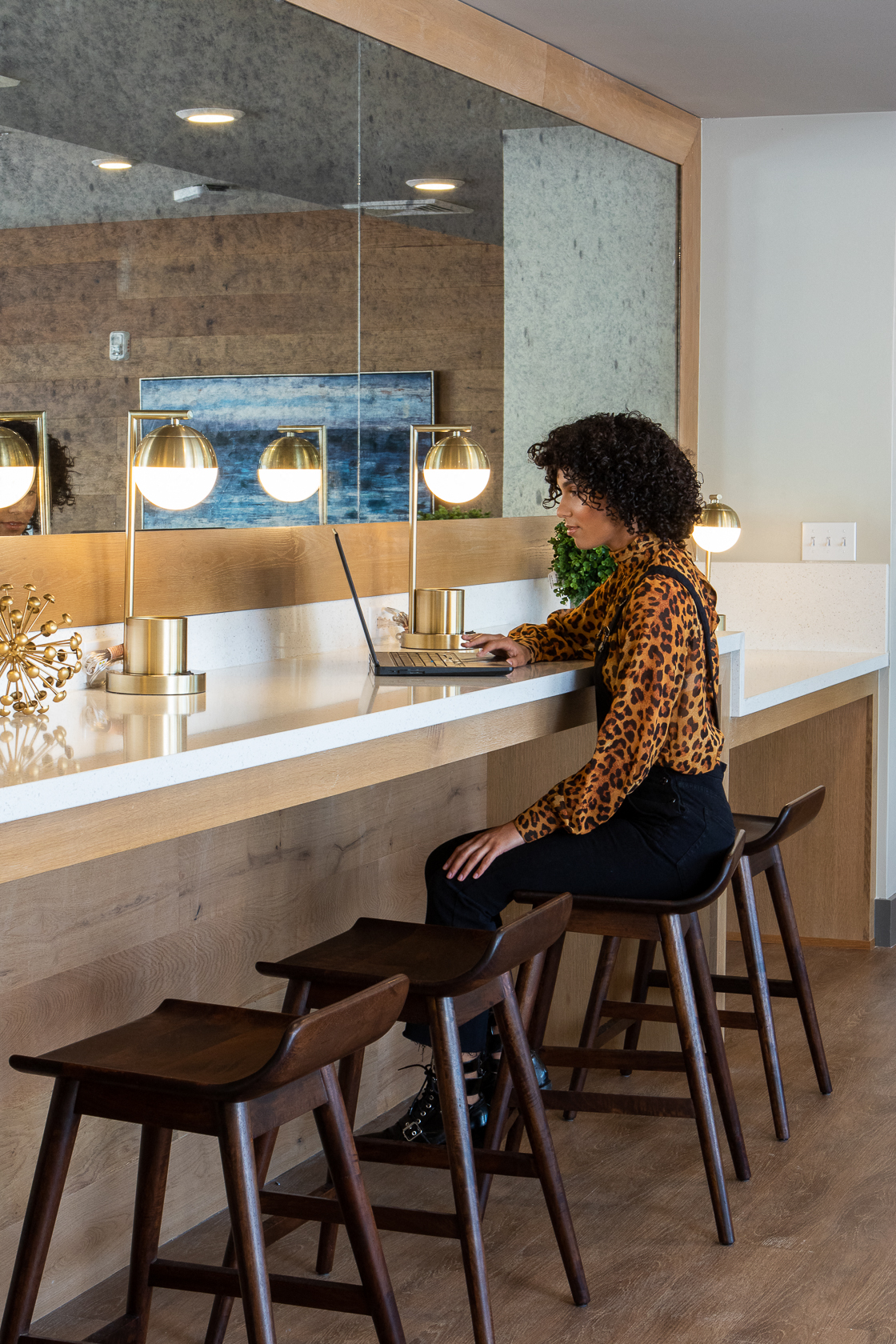 a woman sitting at a bar with a laptop computer