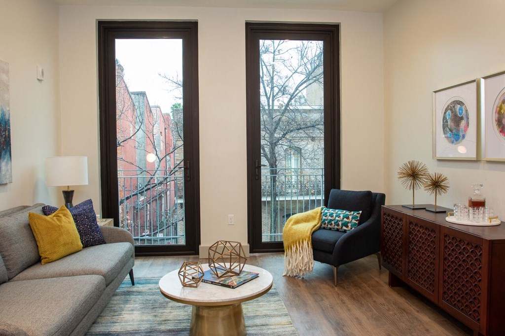 a living room with a couch and a chair and a window