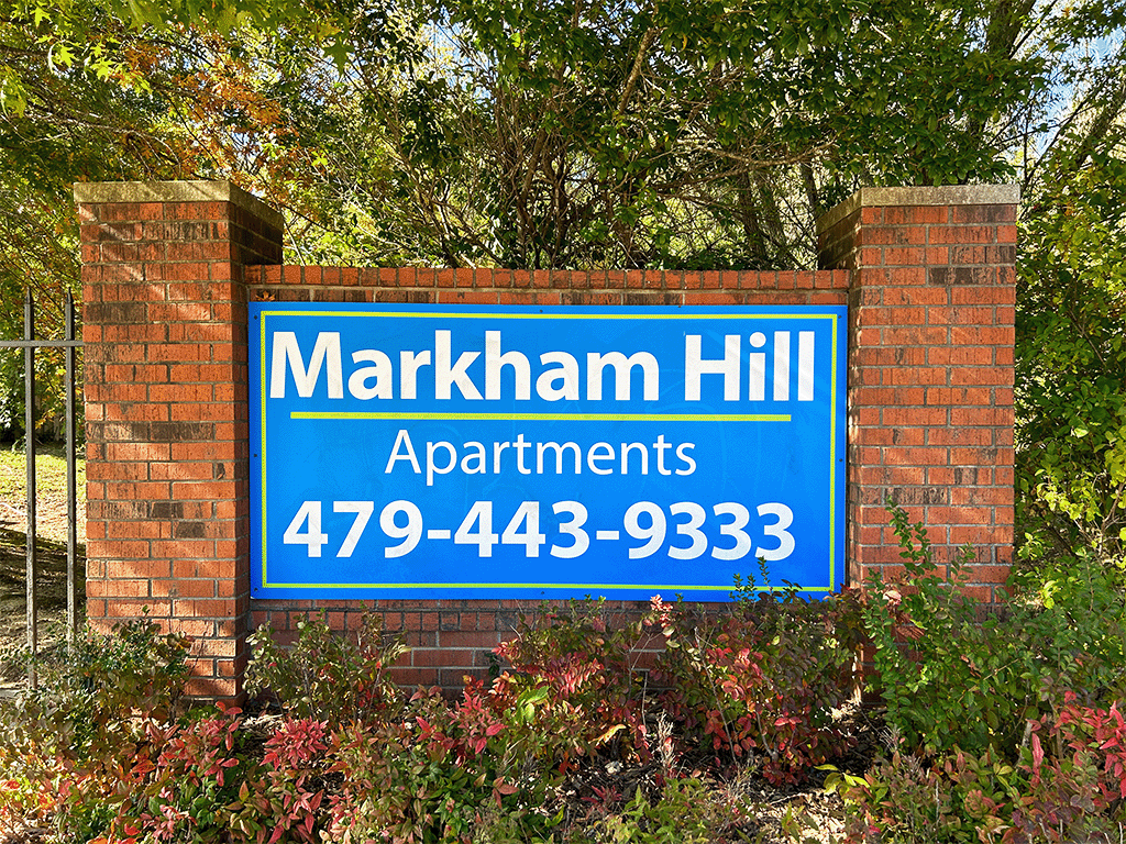 a blue and white sign on a brick wall