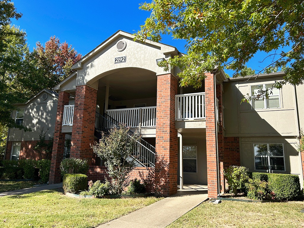 an apartment building with a balcony and a sidewalk