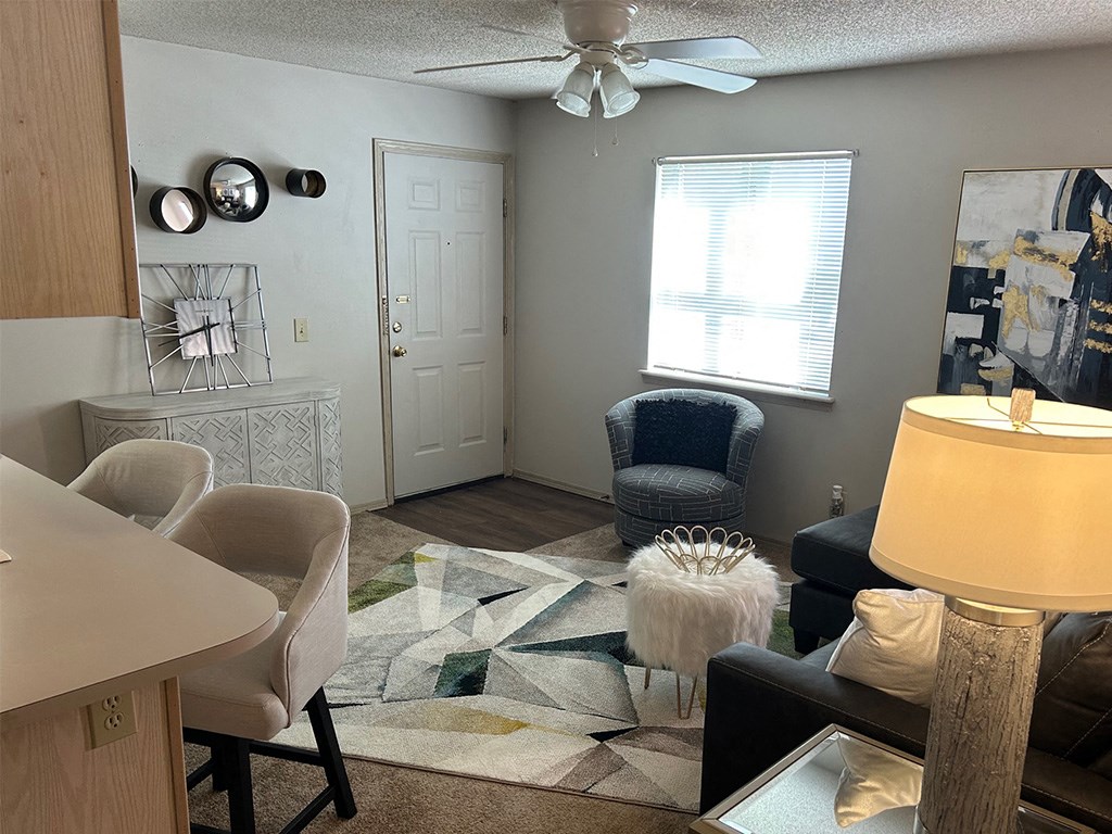 a living room with a ceiling fan and a rug